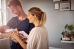 mom and dad holding their newborn baby - estate planning for new parents concept